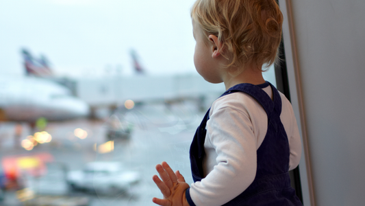 Toddler looking out the window at the airport