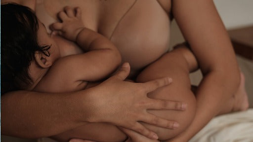 Mother breastfeeding her baby while holding them close in a nurturing embrace