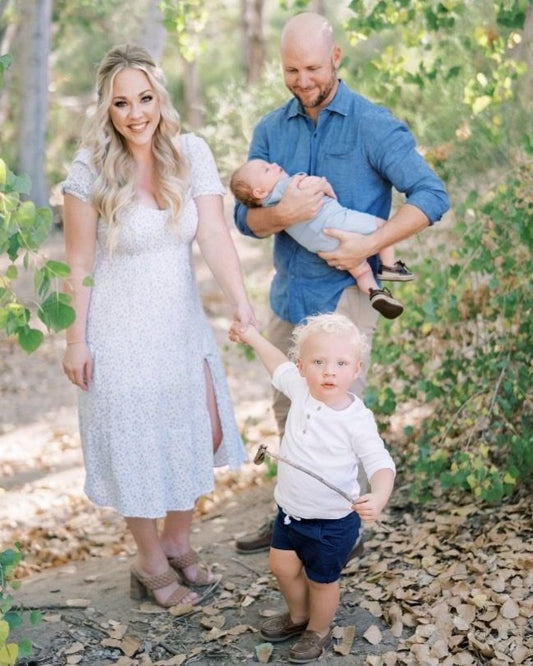Happy family with toddler and newborn outdoors in nature.