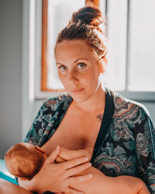 Mother breastfeeding baby in warm natural light