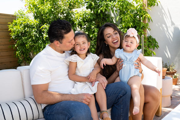 Happy family sitting outside with two young daughters