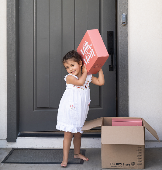 a young girl unboxing Milk by Mom boxes