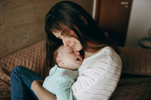 Mother cuddling newborn baby during bonding time, nurturing breast milk feeding and postpartum care at home