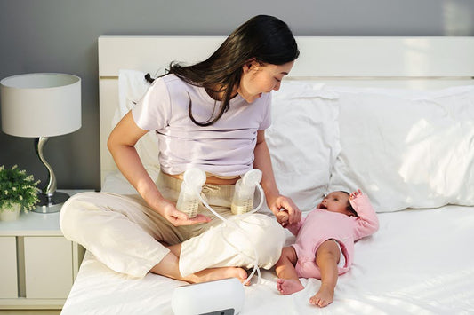 Mom using breast pump while caring for newborn on bed, expressing breast milk for baby feeding and storage