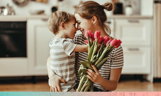 Mother and child sharing a loving moment at home with a bouquet of flowers, highlighting warmth, bonding, and everyday family life in a cozy kitchen setting