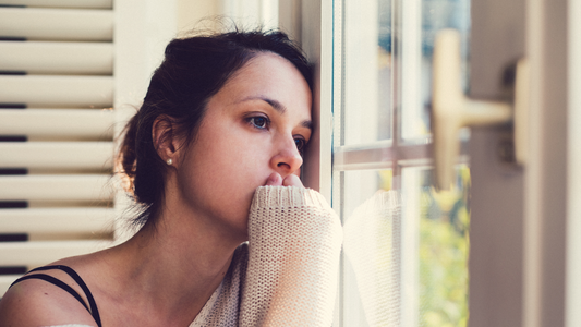 Woman looking out the window with a pensive expression