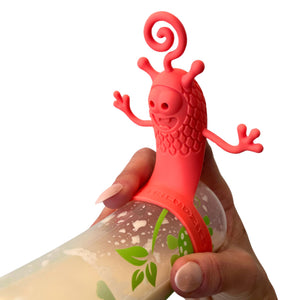 Hand holding a baby bottle filled with milk and topped with a playful red bottle toy attachment designed to entertain babies during feeding