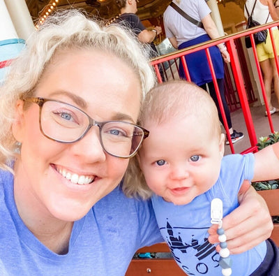 Smiling mom and baby taking a selfie outdoors, capturing a joyful bonding moment that celebrates motherhood, family connection, and everyday life with a young infant