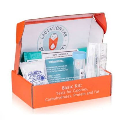 Orange Lactation Lab Basic Kit box open to display breast milk testing supplies including test tube, instructions, ice pack, and materials for analyzing calories, carbohydrates, protein, and fat.
